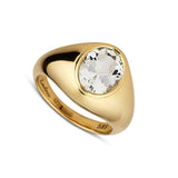 Gold ring with a large white beryl stone on a white background