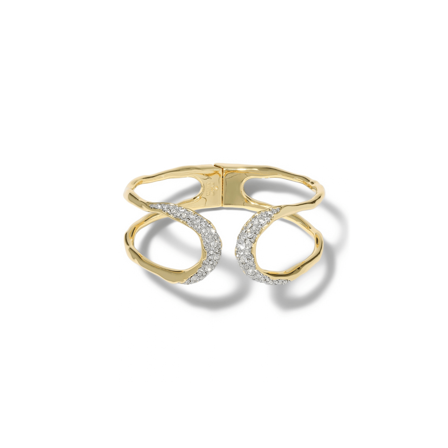 A gold cuff bracelet featuring two interlocking open oval loops, with one loop encrusted with small clear pavé stones.