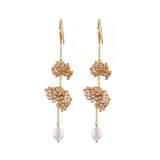 Gold earrings with pearl drops on a white background