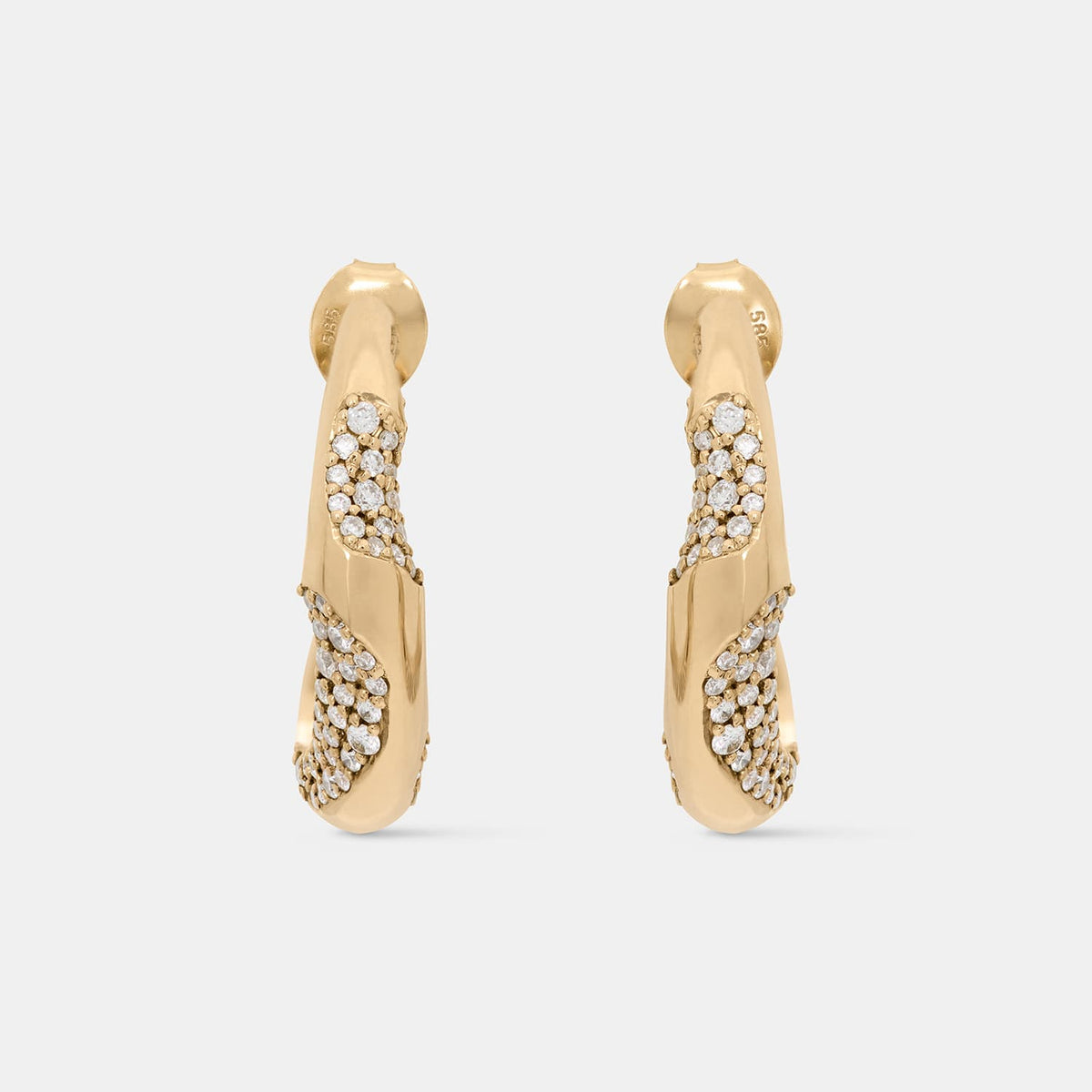 A pair of gold huggie hoop earrings with pavé-set clear stones, shown against a light gray background.