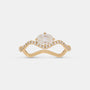 A yellow gold ring featuring a large oval-cut clear center stone and a curved shank paved with small round stones, shown on a light gray background.