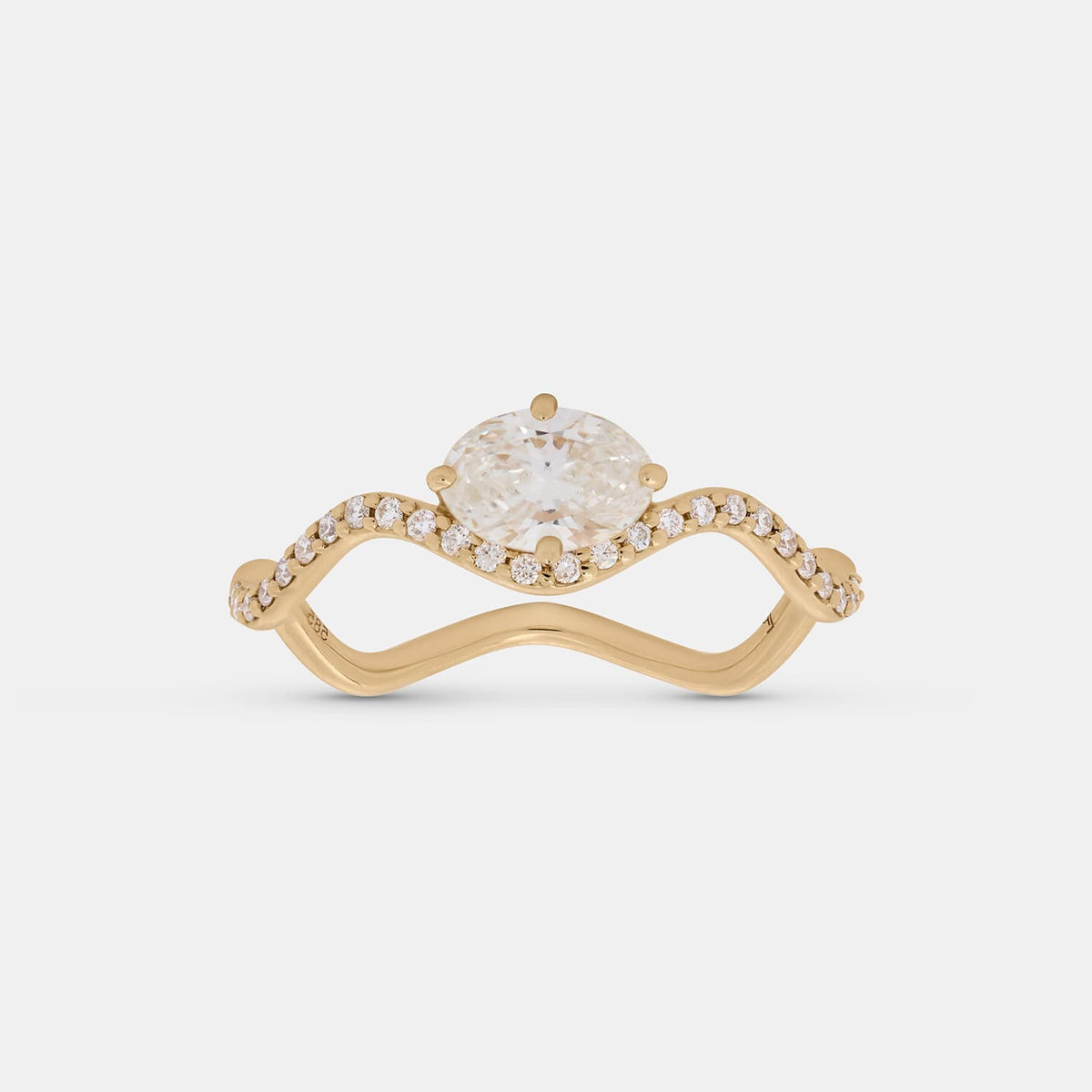 A yellow gold ring featuring a large oval-cut clear center stone and a curved shank paved with small round stones, shown on a light gray background.