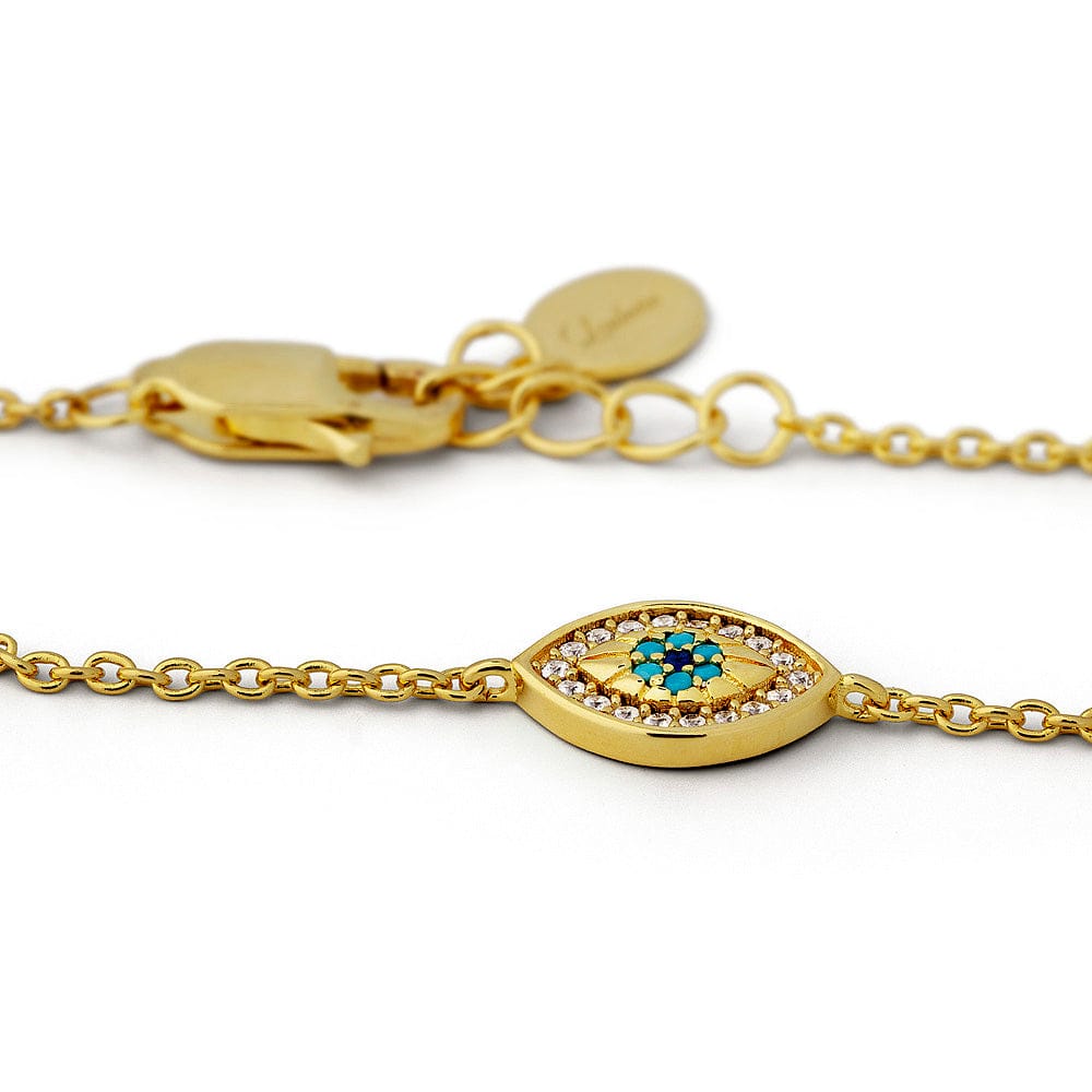 Gold bracelet with an eye-shaped charm featuring a blue gemstone on a white background