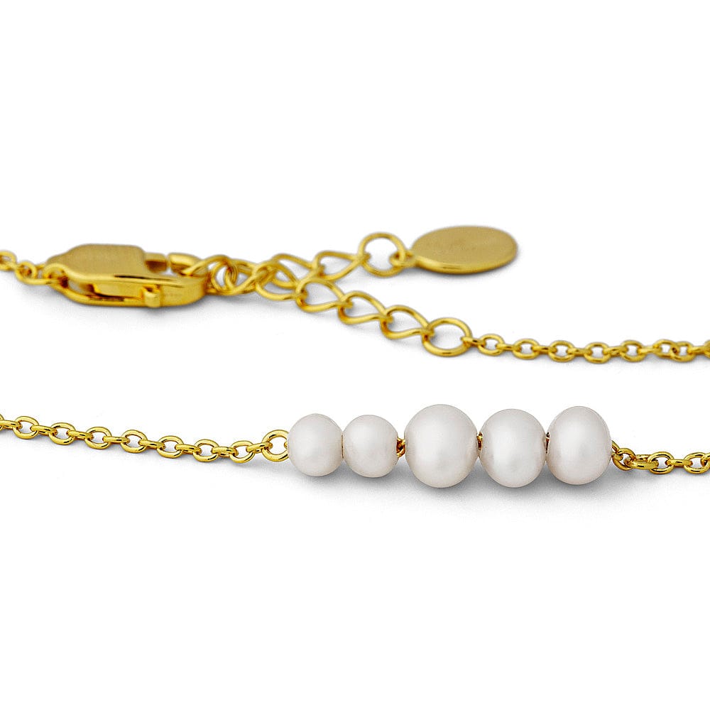 Gold chain bracelet with white pearls on a white background