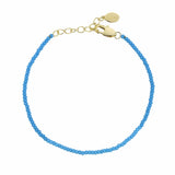 turquoise beaded bracelet with gold clasp on a white background