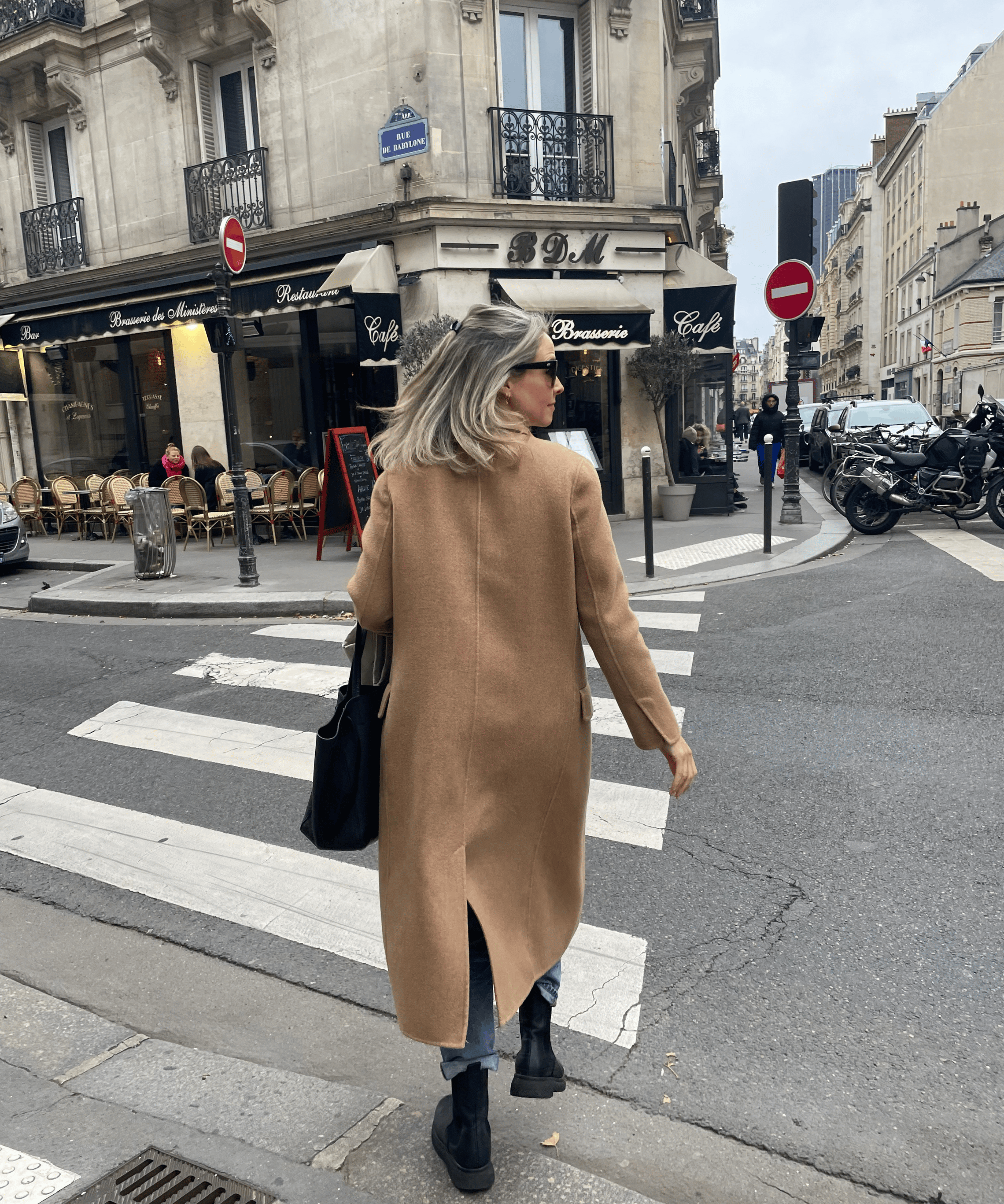 A stylish woman walking across a crosswalk in Paris
